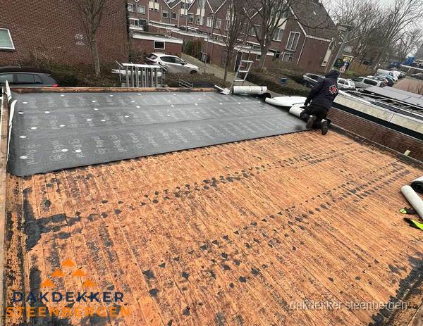 Dakdekker legt onderlaag op plat dak met houten constructie in Steenbergen