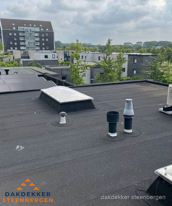 Groot plat dak met lichtkoepel en dakdoorvoeren in Steenbergen