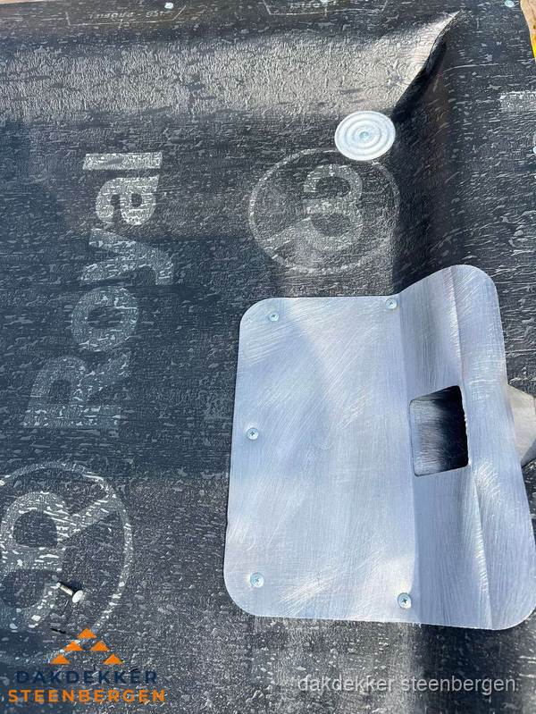 Dakdoorvoer met metalen afvoerplaat op bitumen dak in Steenbergen