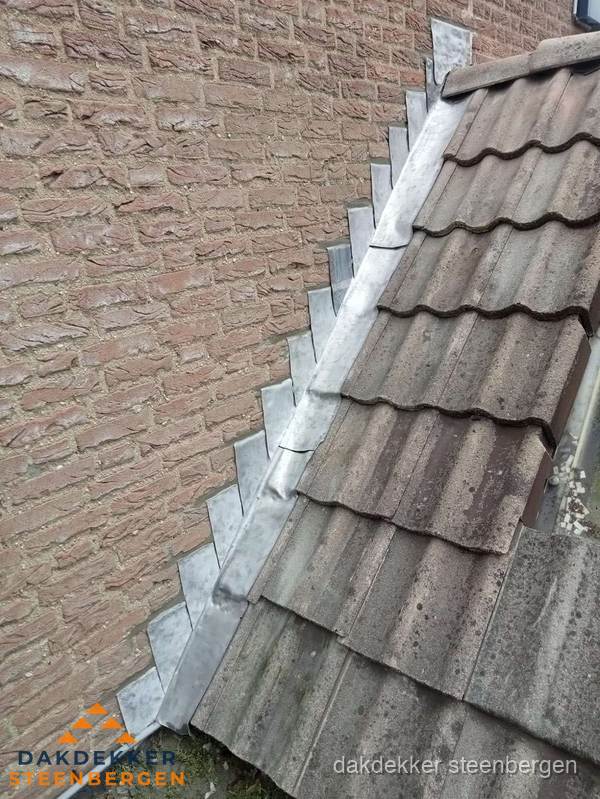 Loodslabben langs dakaansluiting bij bakstenen muur in Steenbergen