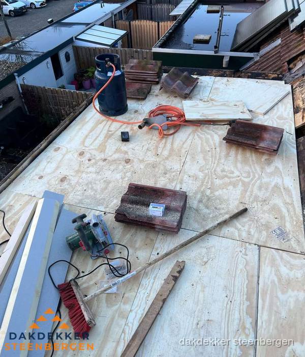 Dakreparatie werkzaamheden op plat dak met gereedschap in Steenbergen